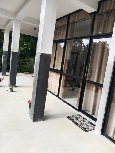 a building with black and white columns and windows at Ella glory inn in Ella