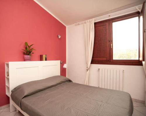 - une chambre rouge avec un lit et une fenêtre dans l'établissement Casa Nettuno, à Maddalenedda