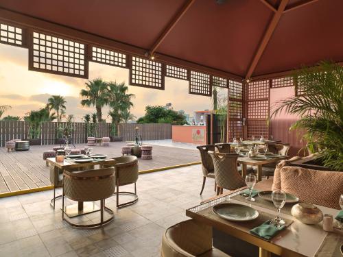a restaurant with tables and chairs and a patio at Leonardo Laura Beach & Splash Resort in Paphos City