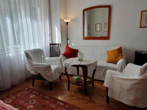 uma sala de estar com um sofá, uma mesa e um espelho em Memory Lane em Budapeste