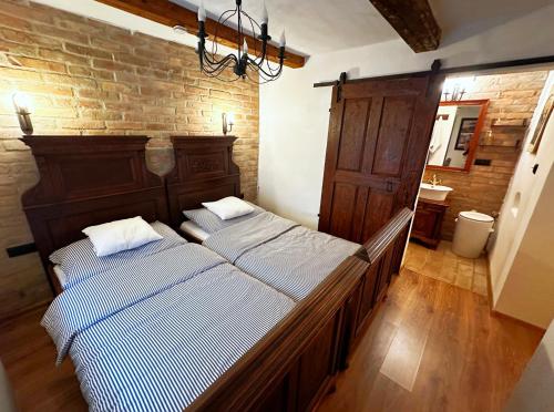 two beds in a bedroom with a brick wall at Baboško in Rimavská Sobota
