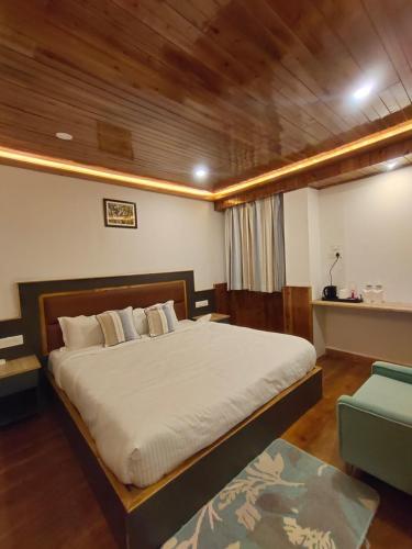 a bedroom with a large bed and a chair at The Garuda Hotel And Spa in Gangtok