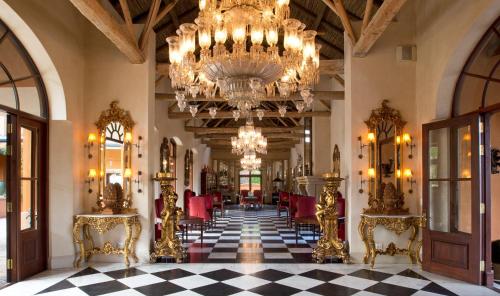 a large room with a chandelier and a checkerboard floor at La Residence in Franschhoek