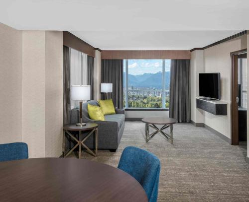 a living room with a couch and a television at Hilton Vancouver Metrotown in Burnaby