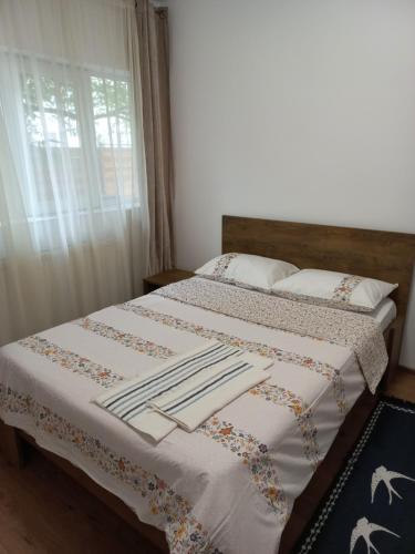 una camera da letto con un letto con lenzuola bianche e una finestra di Casa Galina a Bucarest