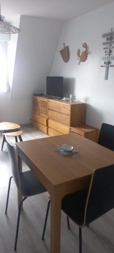 Cette chambre dispose d'une table, de chaises et d'un bureau. dans l'établissement Appartement lumineux et fonctionnel en bord de mer, à Villers-sur-Mer