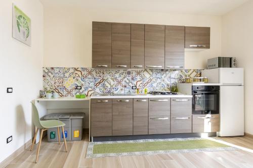 a kitchen with brown cabinets and a white refrigerator at Sefy Mare A Selinunte in Marinella di Selinunte