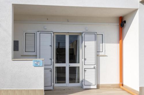 an open door to a white building with a window at Sefy Mare A Selinunte in Marinella di Selinunte