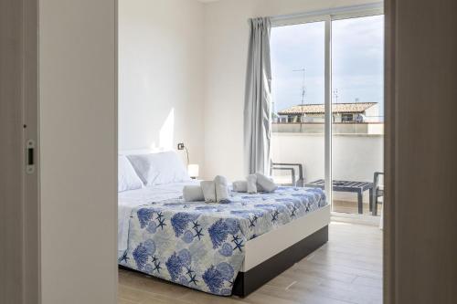 a bedroom with a bed and a balcony at Sefy Mare A Selinunte in Marinella di Selinunte