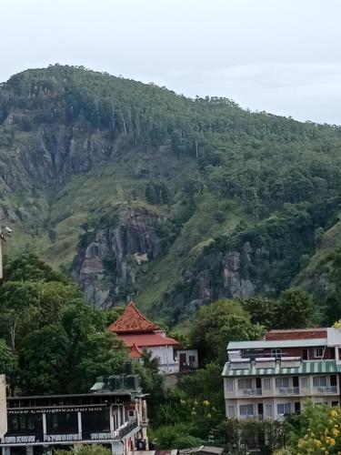 a mountain in the background with houses and a building at Ella glory inn in Ella