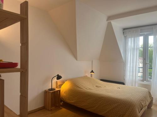 biała sypialnia z łóżkiem i oknem w obiekcie Comfy flat 7 min away from Disney w mieście Serris