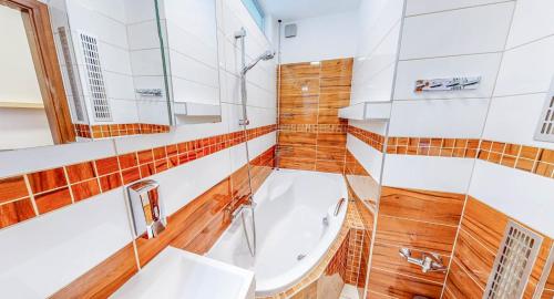 a bathroom with a tub and a sink at Nový apartmán v Ostravě u Mišky s akváriem a výhledem z balkonu na Beskydy in Ostrava