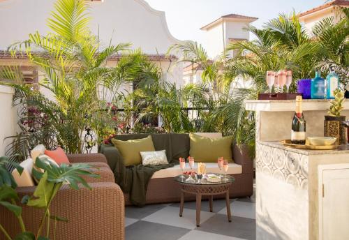 a patio with a couch and a table at LohonoStays Colina Villa A in Assagao