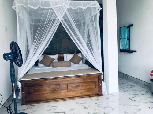 a bed with a canopy in a room at Ella glory inn in Ella