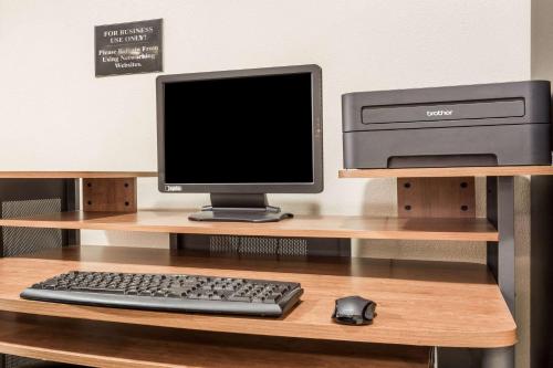 a computer monitor and a keyboard and mouse on a desk at Super 8 by Wyndham Moose Jaw SK in Moose Jaw