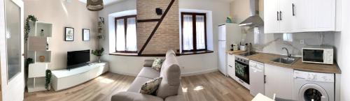 a large living room with a couch and a kitchen at Casa de los Canteros in Toledo