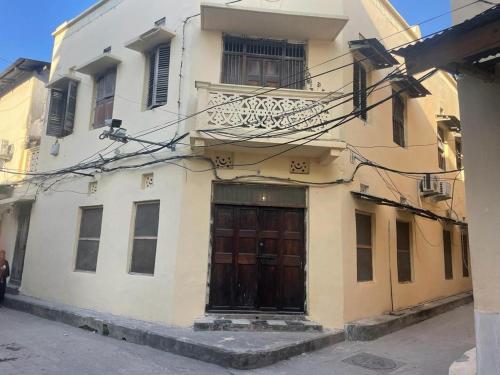 ein Gebäude mit einer Holztür auf einer Straße in der Unterkunft SAFARI in Stone Town