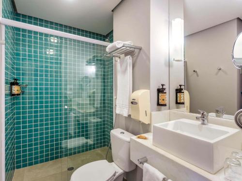La salle de bains est pourvue de toilettes, d'un lavabo et d'une douche. dans l'établissement Mercure Sao Paulo JK, à São Paulo
