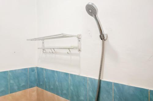 eine Dusche mit Duschkopf an der Wand in der Unterkunft Urbanview Ava Guest House Goa Gong in Jimbaran