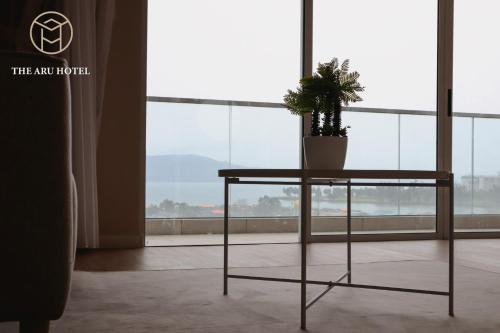 a plant on a table in front of a window at The Aru Hotel at Aru Suites in Kota Kinabalu