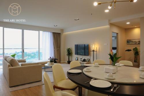 a dining room and living room with a table and chairs at The Aru Hotel at Aru Suites in Kota Kinabalu