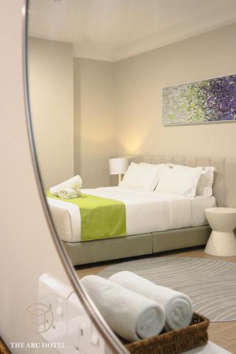 a bedroom with a bed and a mirror at The Aru Hotel at Aru Suites in Kota Kinabalu
