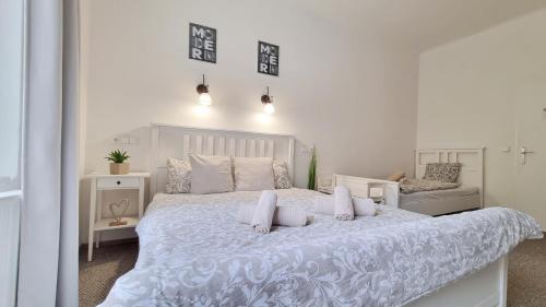 a white bedroom with a white bed and a couch at Finnem Rentals Zíkova in Prague