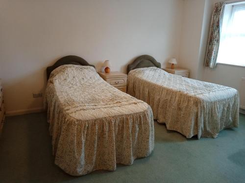 sypialnia z 2 łóżkami i oknem w obiekcie Glen Dhoo Country Cottages - The Apartment w mieście Onchan