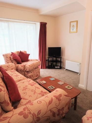 un soggiorno con divano e tavolo di Glen Dhoo Country Cottages - The Apartment a Onchan
