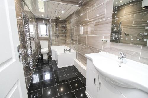 a bathroom with two sinks and a tub and a toilet at Remarkable 4-Bed House in Bradford in Bradford