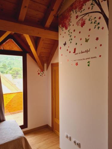a bedroom with a tree with leaves on the wall at Sierra de Cazorla in Arroyo Frio