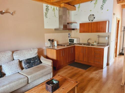 ein Wohnzimmer mit einem Sofa und einer Küche in der Unterkunft Sierra de Cazorla in Arroyo Frio