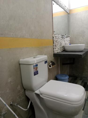 a bathroom with a white toilet and a sink at Ella glory inn in Ella