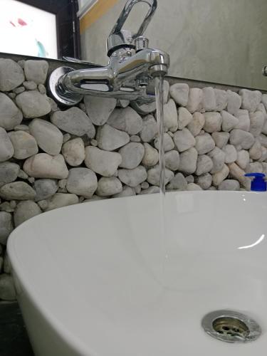 a sink in a bathroom with a stone wall at Ella glory inn in Ella