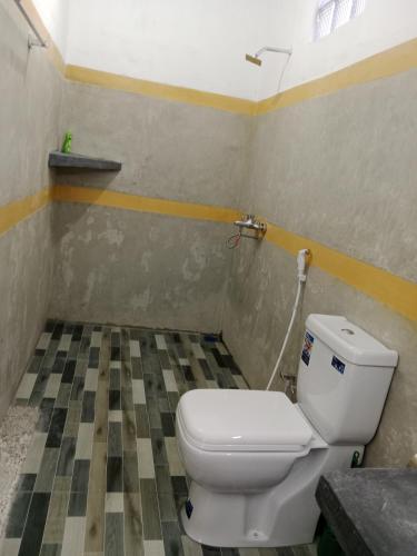 a bathroom with a toilet and a checkered floor at Ella glory inn in Ella