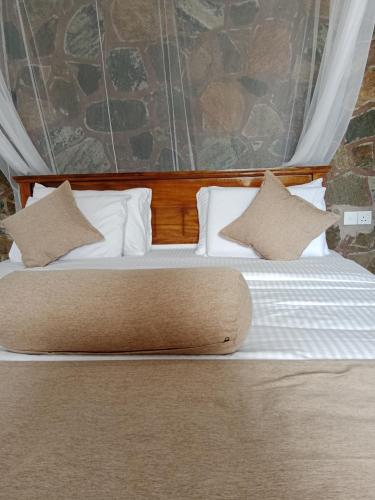 a large bed with white pillows in a room at Ella glory inn in Ella