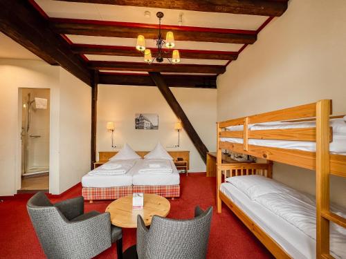 a bedroom with two bunk beds and a table and chairs at Herzogskelter Restaurant Hotel in Güglingen