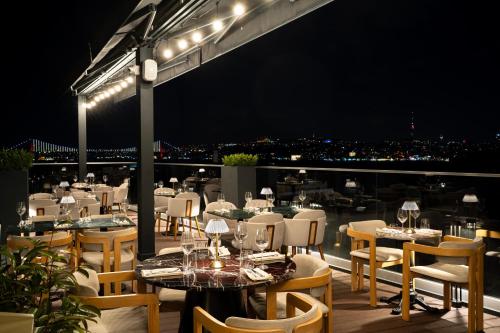 a restaurant with white tables and chairs at night at Loop Hotel Bosphorus İstanbul in Istanbul