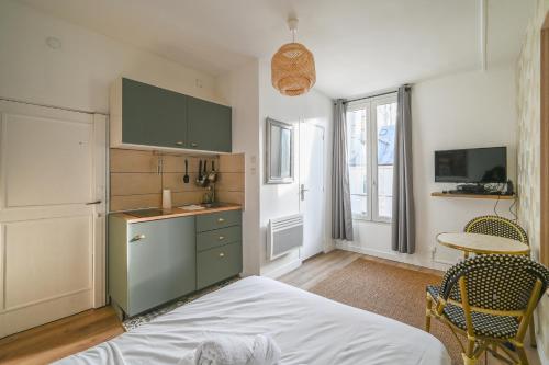 une chambre avec un lit et une table et une cuisine dans l'établissement Magnifique appartement au centre de Paris 44, à Paris
