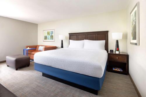 a hotel room with a large bed and a chair at Hampton Inn Naples-Central in Naples