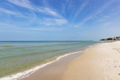 a beach with the ocean and a blue sky at Hampton Inn Naples-Central in Naples