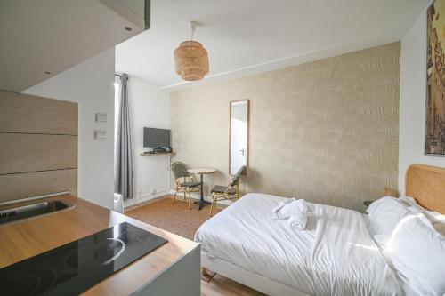 une petite chambre avec un lit et une cuisine dans l'établissement Magnifique appartement au centre de Paris 44, à Paris