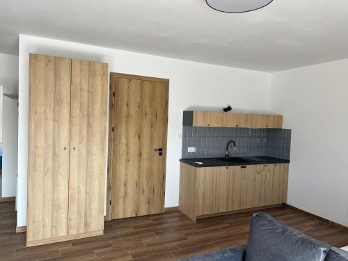 a kitchen with two wooden cabinets and a sink at Aquarius Stawy Walczewskiego 2 in Grodzisk Mazowiecki