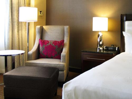a bedroom with a bed and a chair with a pillow at Hilton Minneapolis in Minneapolis