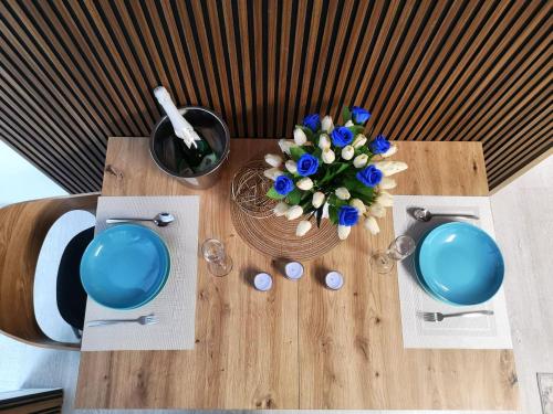 a wooden table with a vase of flowers on it at Apartamenty Lumax in Gryfice