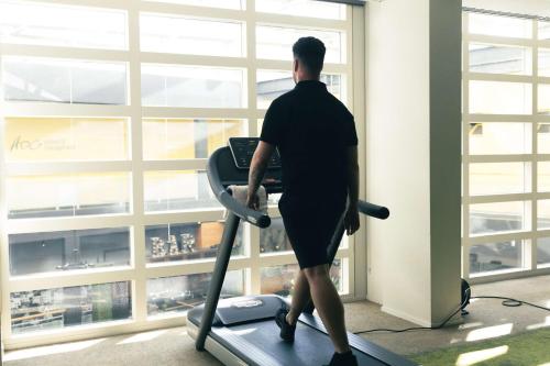 a man walking on a treadmill in a gym at Flonk Hotel Groningen Centre, BW Signature Collection in Groningen