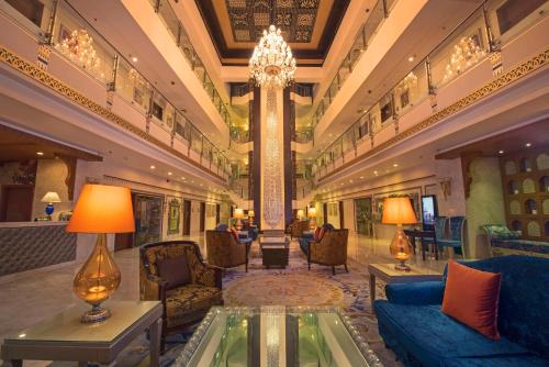 a lobby with couches and chairs in a building at Radisson Blu Udaipur Palace Resort & Spa in Udaipur