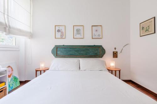 a bedroom with a large white bed with two candles at Vodice Flexyrent apartment in Milan