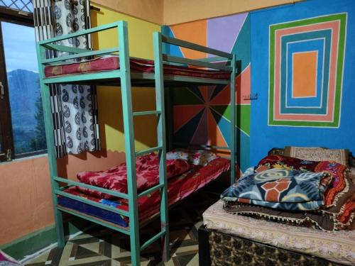 Cette chambre comprend deux lits superposés et un lit. dans l'établissement Moon hotel Tungnath, à Chopta