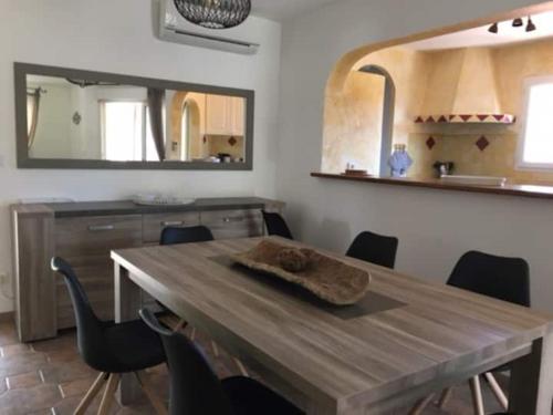 a dining room with a wooden table and a mirror at Villa Porto Vecchio 8p in Porto-Vecchio